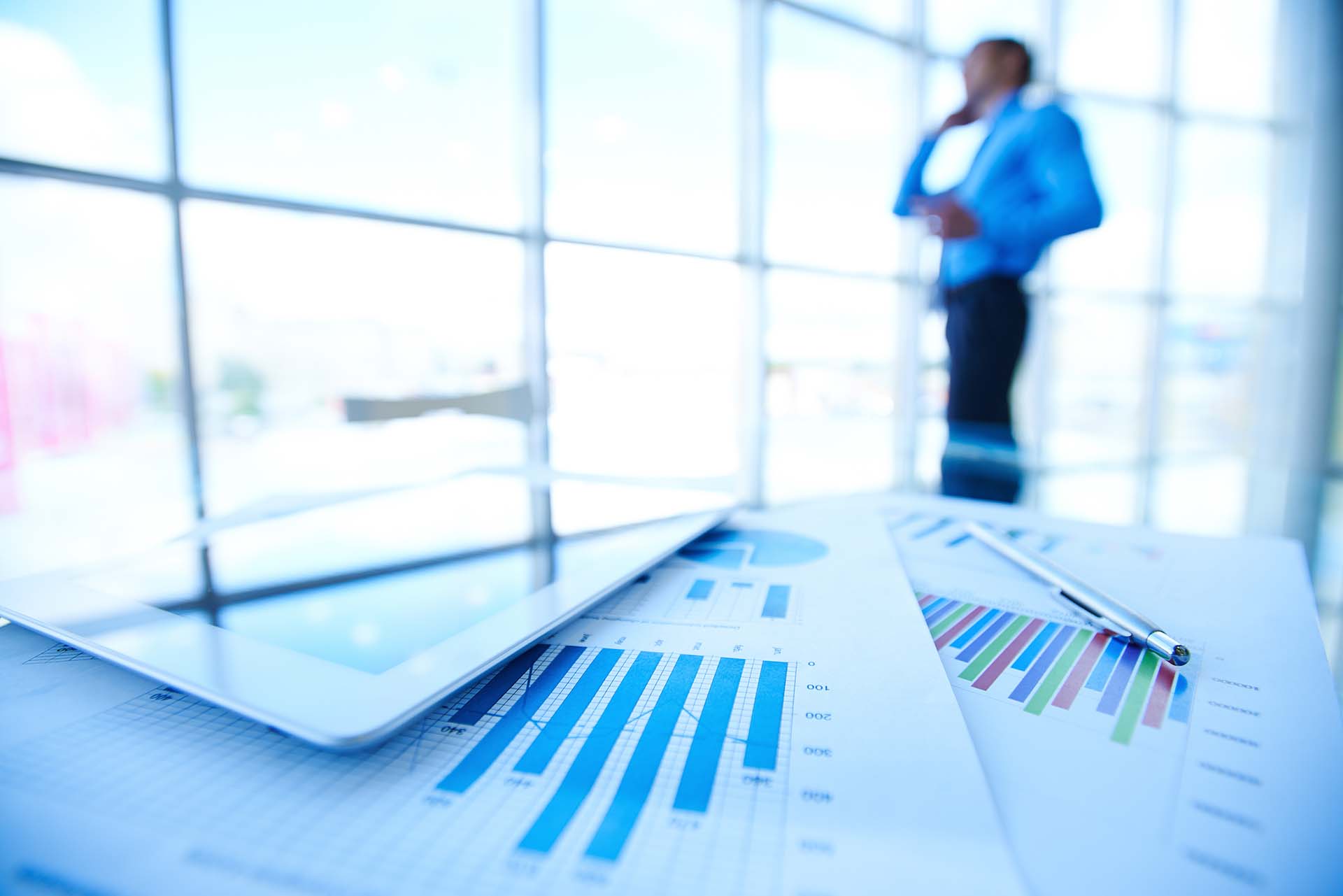 statistic documents with businessman blurred background
