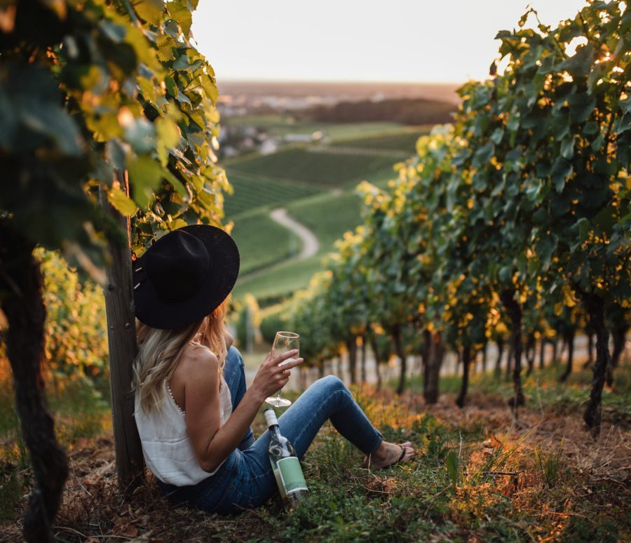 young blonde woman relaxing vineyards summer season with bottle wine young blonde woman relaxing vineyards summer season with bottle wine